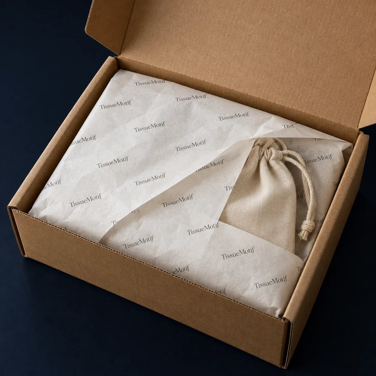 Custom printed tissue wrapping an accessory pouch inside a protective kraft shipping box
